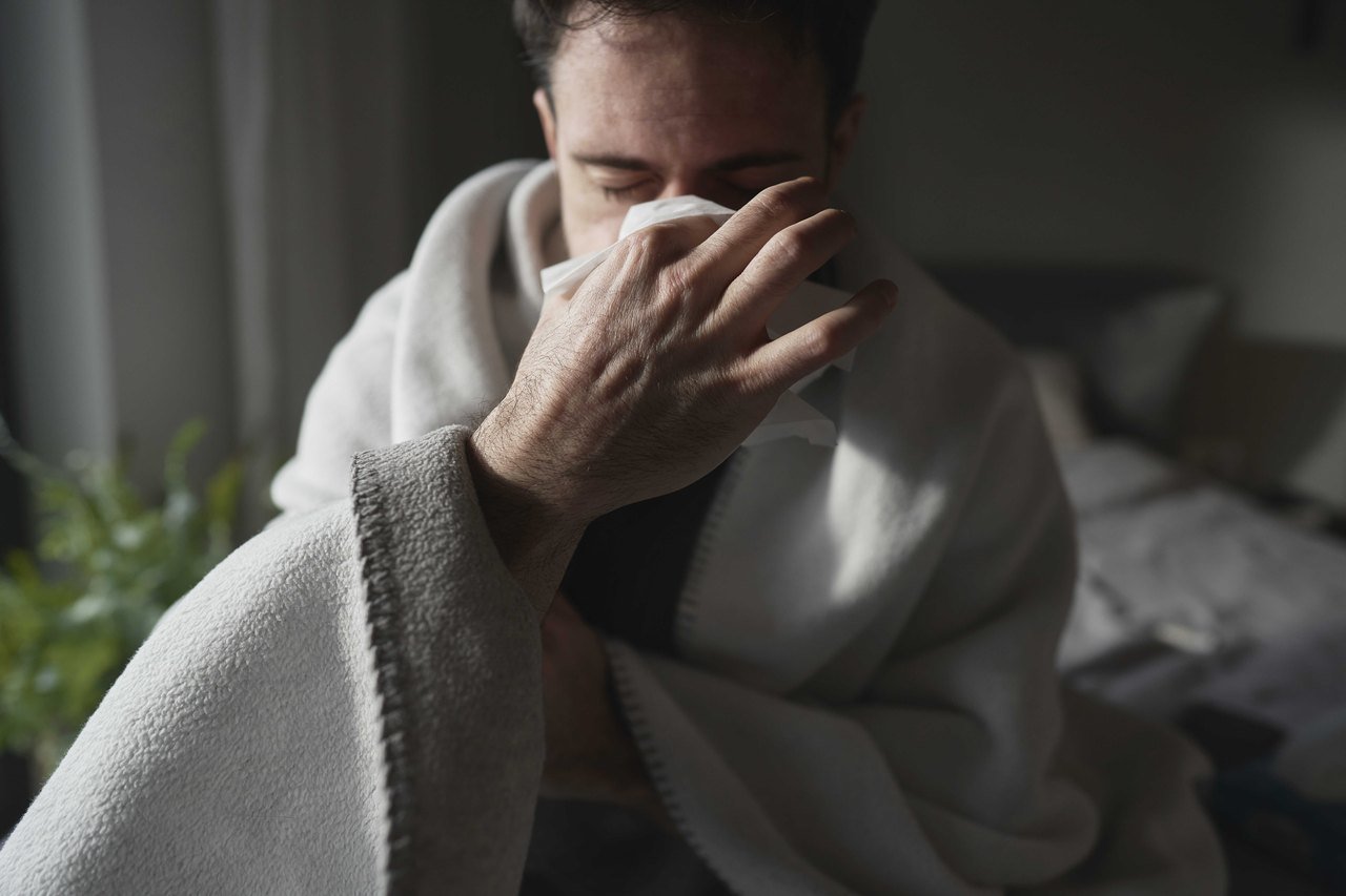 Congestion that does not clear and the snoring that comes with it Man sitting up in bed with a blanket, blowing his nose