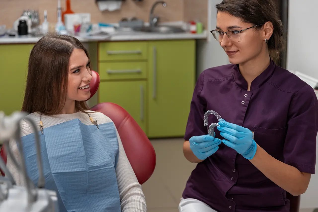 Dentist showing a custom oral appliance to a patient during a Vivos sleep apnea consultation