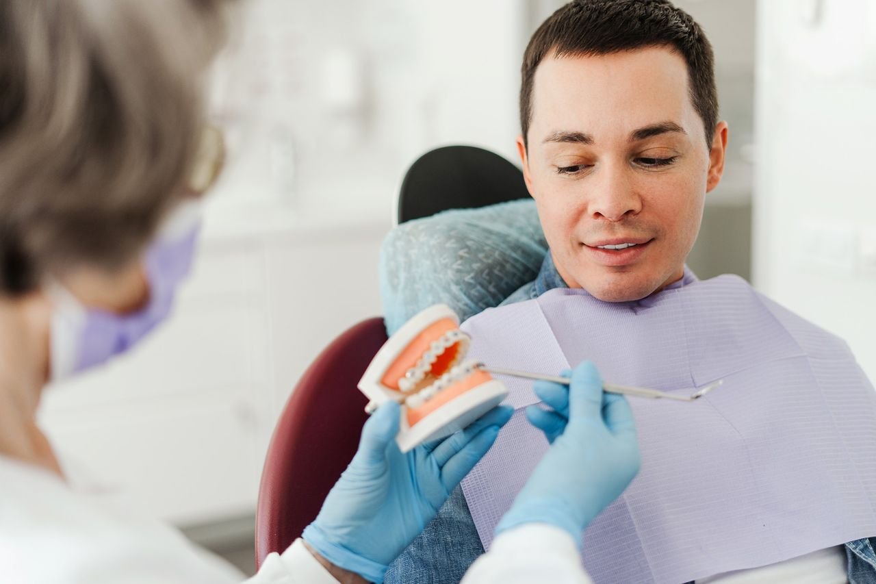 Provider using a dental model to talk through options with an adult patient