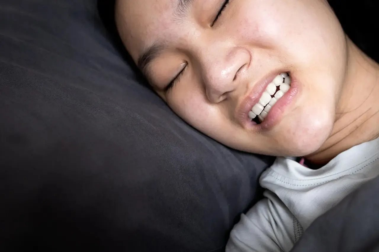 Detailed view of a person grinding teeth during sleep, illustrating the link between bruxism and sleep apnea