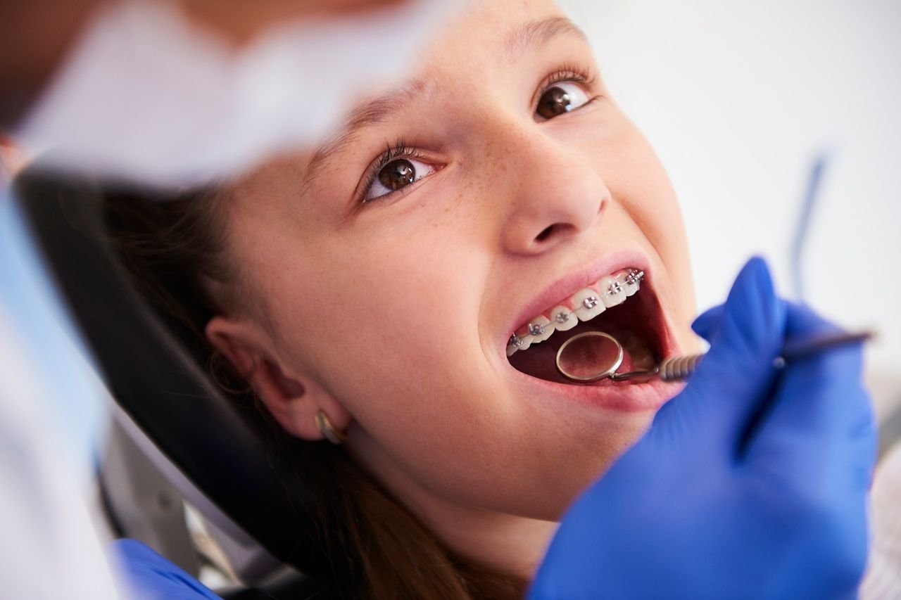 Provider examining a girl's bite and braces during a dental exam